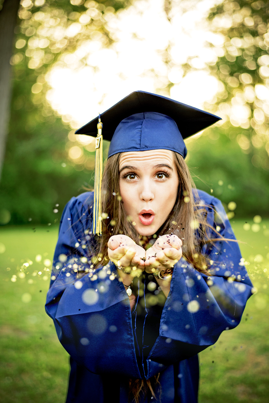 Michigan Senior Portraits - High School Senior Girl Blowing Glitter at Camera in Graduation Outfit