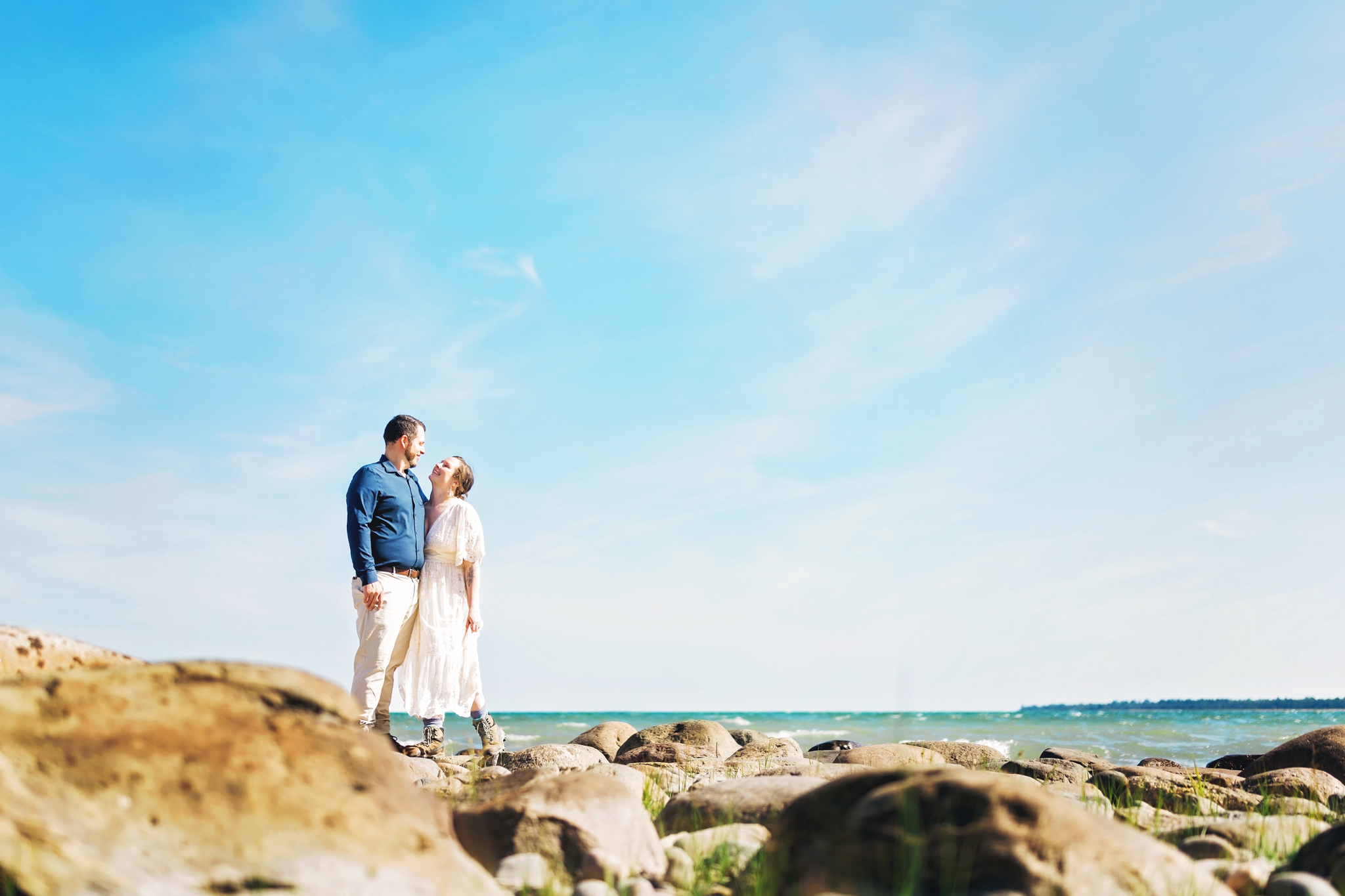 Adventurous Couple on Lake Huron Shoreline in Negwegon State Park for their Adventure Elopement in Northern Michigan