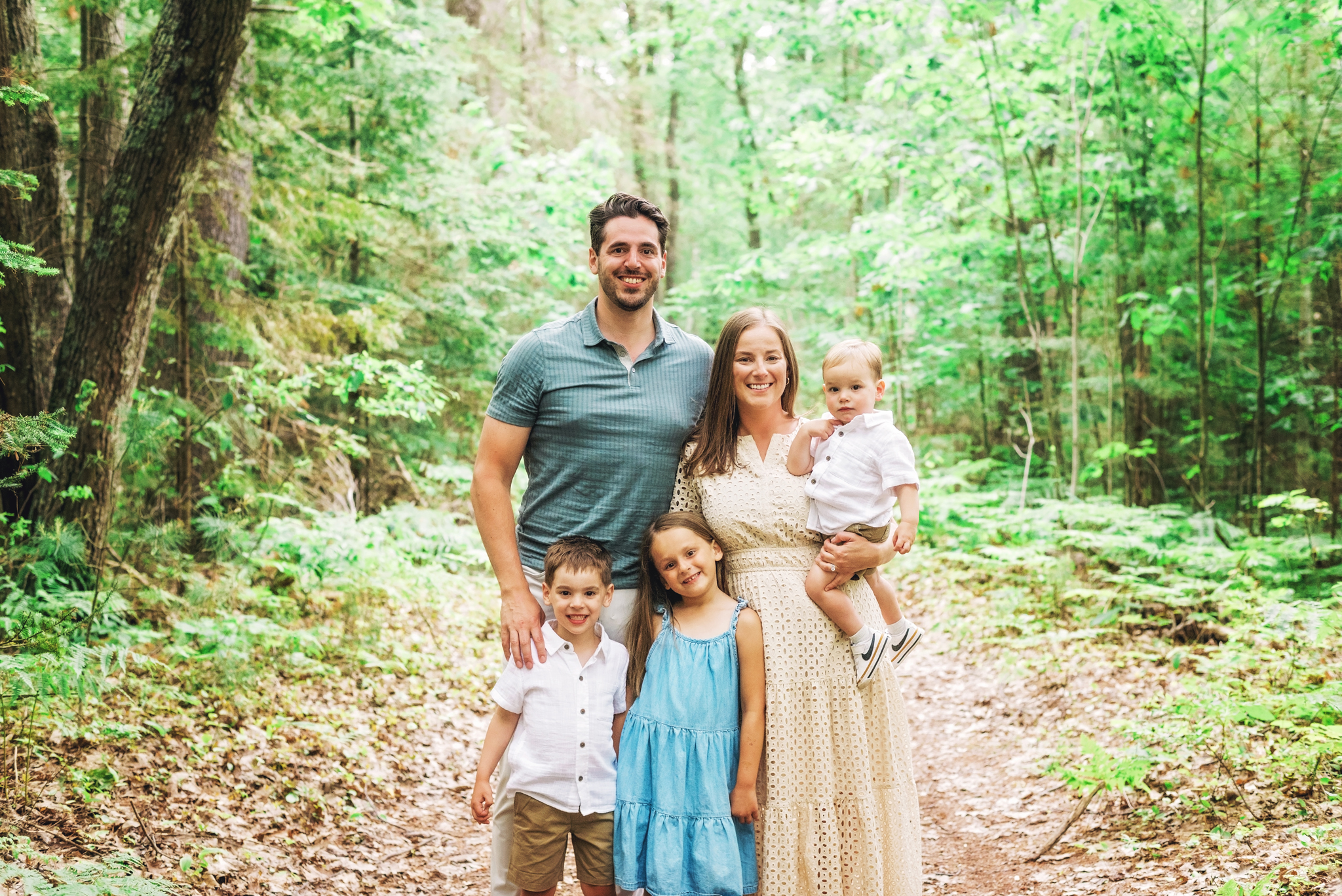 Family on forest trail in Negwegon State Park enjoying the natural scenery and their adventure together.