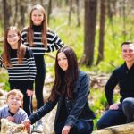 Family enjoying spring green forest during their portrait session in Northern Michigan.