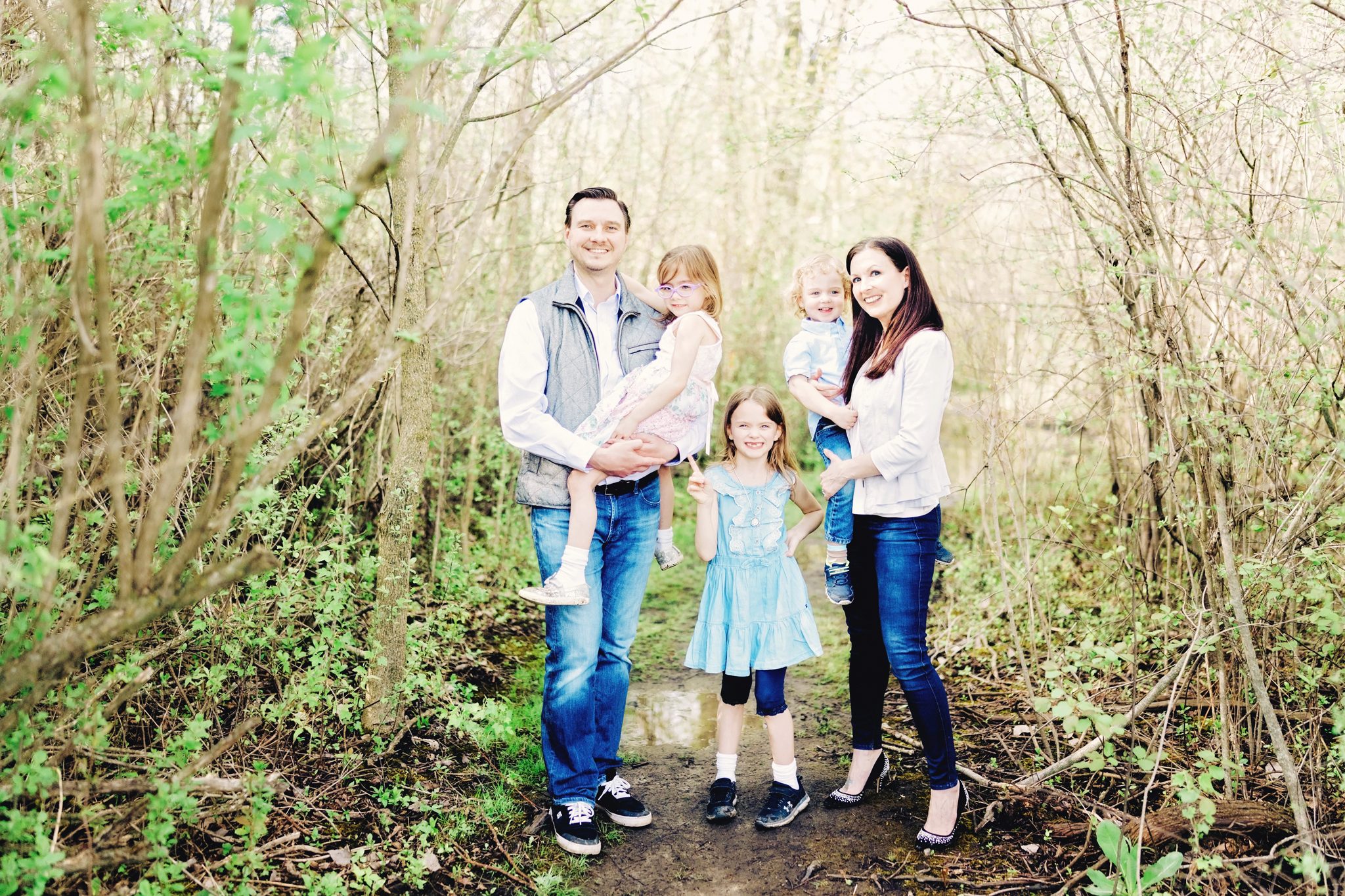 Family enjoying spring green forest trail in Northern Michigan.
